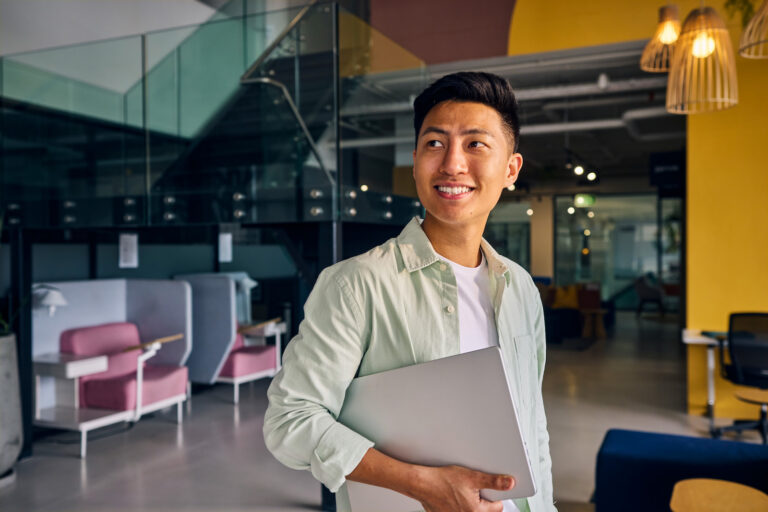 Person Holding Laptop in Office